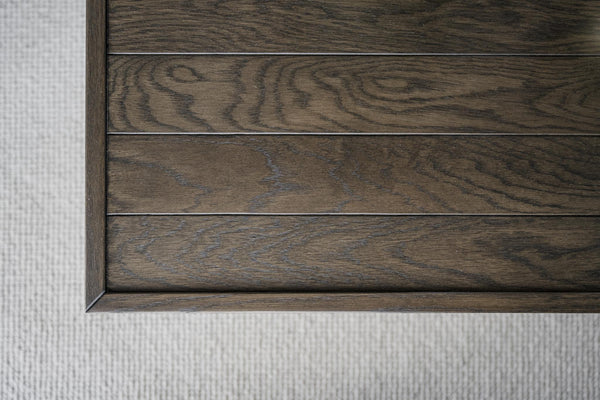 Mörkbrun träpanel med synlig åderstruktur och naturlig träkaraktär, detalj av hörn och kant