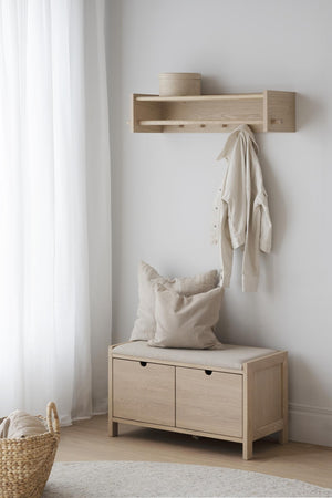 Hallmöbel i ljust trä med bänk, förvaringslådor och hylla med krokar för kläder i minimalistisk stil