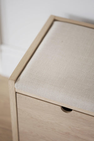 Hallbänk med stoppad sits i beige tyg och ljust trä med låda