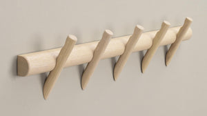 Krokrad i ljust trä med fem böjda krokar monterad på vägg