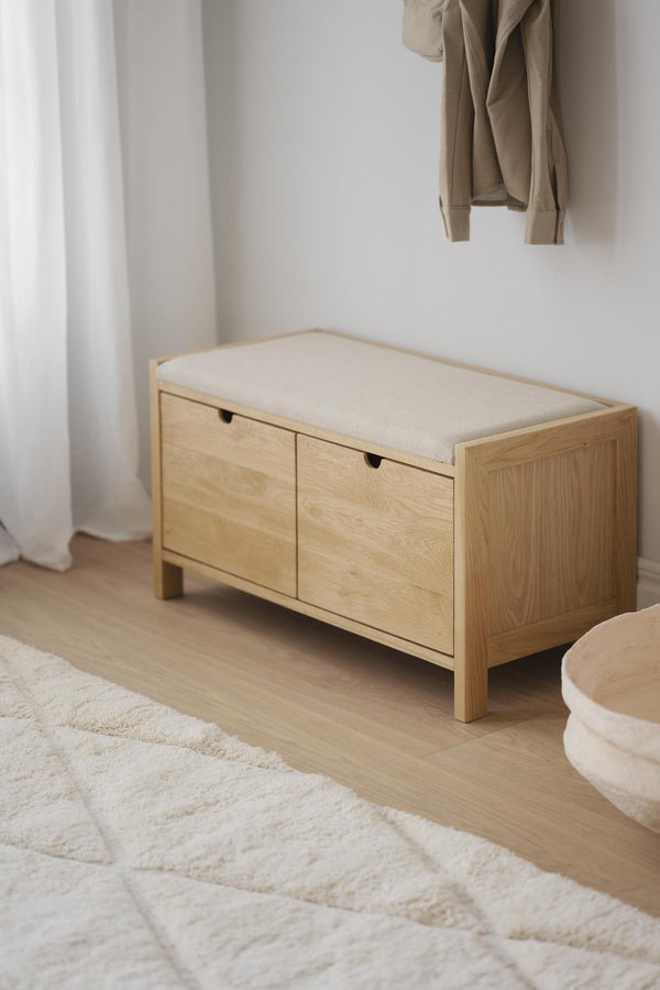 Bänk med förvaring i ljust trä och vit stoppning, perfekt för hall eller sovrum