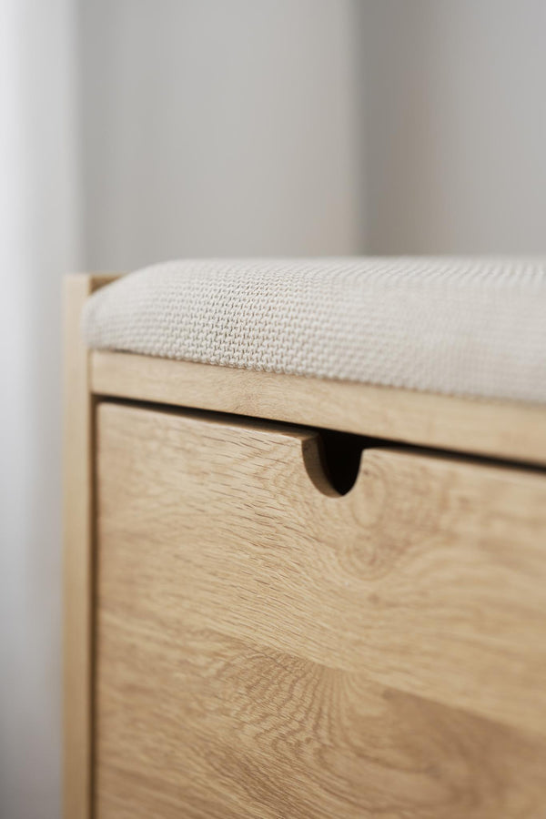 Hallbänk i ljust trä med stoppad sits i beige tyg och utdragbar låda