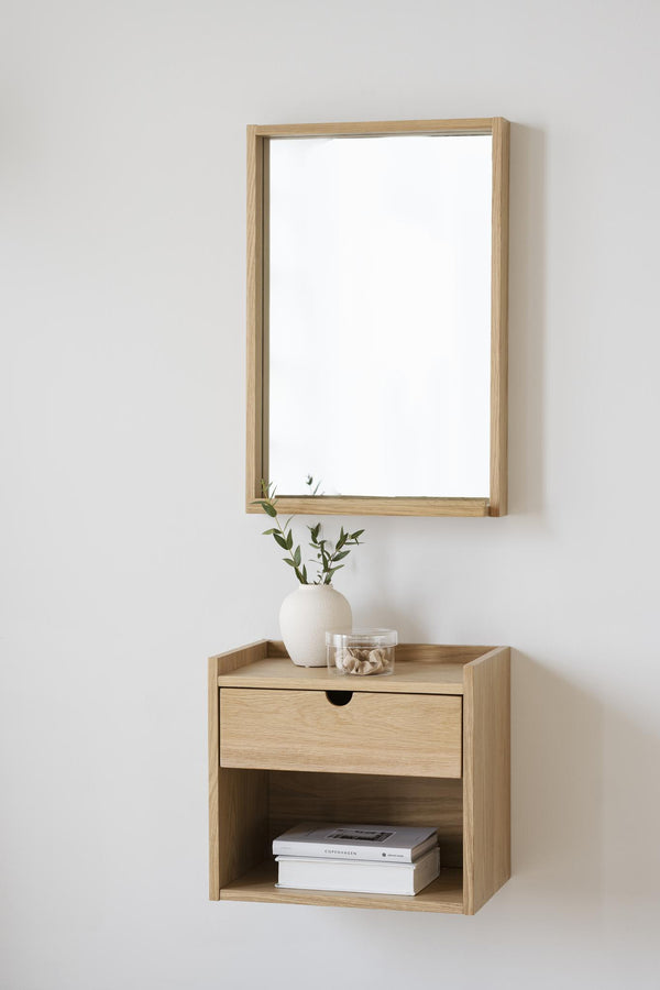 Väggmonterad sängbord i ljust trä med spegel, låda och öppen hylla i minimalistisk skandinavisk stil