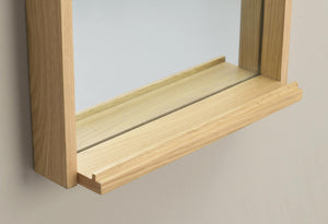 Fönsterbänk i ljust trä med profilerad kant monterad under fönsterram