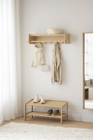 Ljus hallmöbel i trä med hyllplan, krokar och skohylla i minimalistisk skandinavisk stil