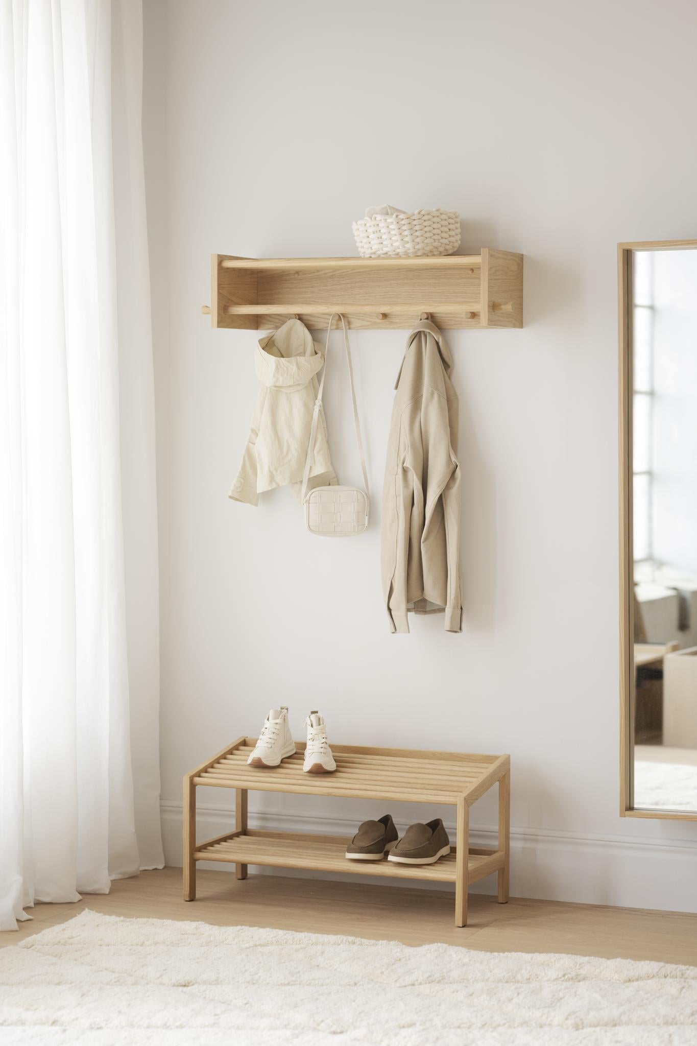 Ljus hallmöbel i trä med hyllplan, krokar och skohylla i minimalistisk skandinavisk stil