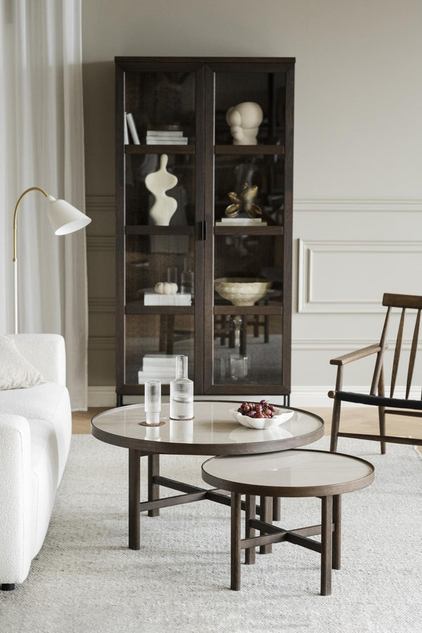 Soffbord i mörkt trä med vit skiva och vitrinskåp med glashyllor i modernt vardagsrum