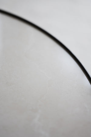 Närbild av svart böjd linje mot vit bakgrund, minimalistisk och grafisk detalj