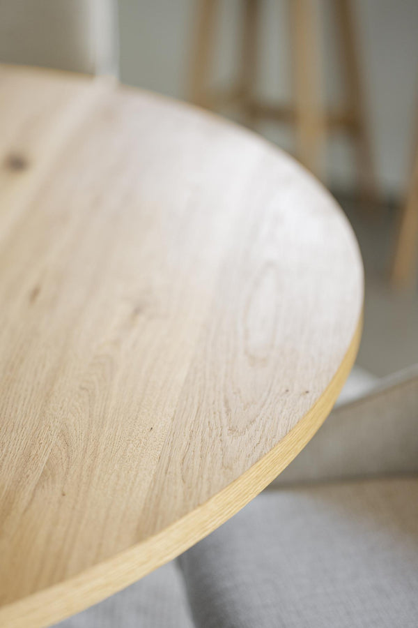 Rund bordsskiva i ljust trä med synlig ådringsstruktur och kantfanér