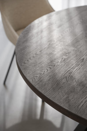 Rund matbord i mörkgrå ek med synlig trästruktur och elegant träådring, närbild