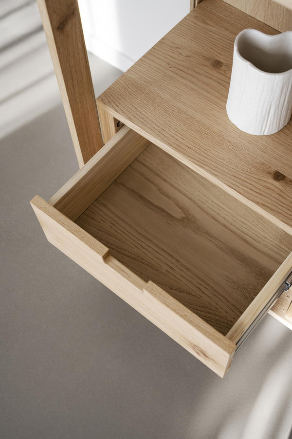 Öppen låda i ekfanér på sängbord med vit vas, visar förvaring och naturlig trästruktur