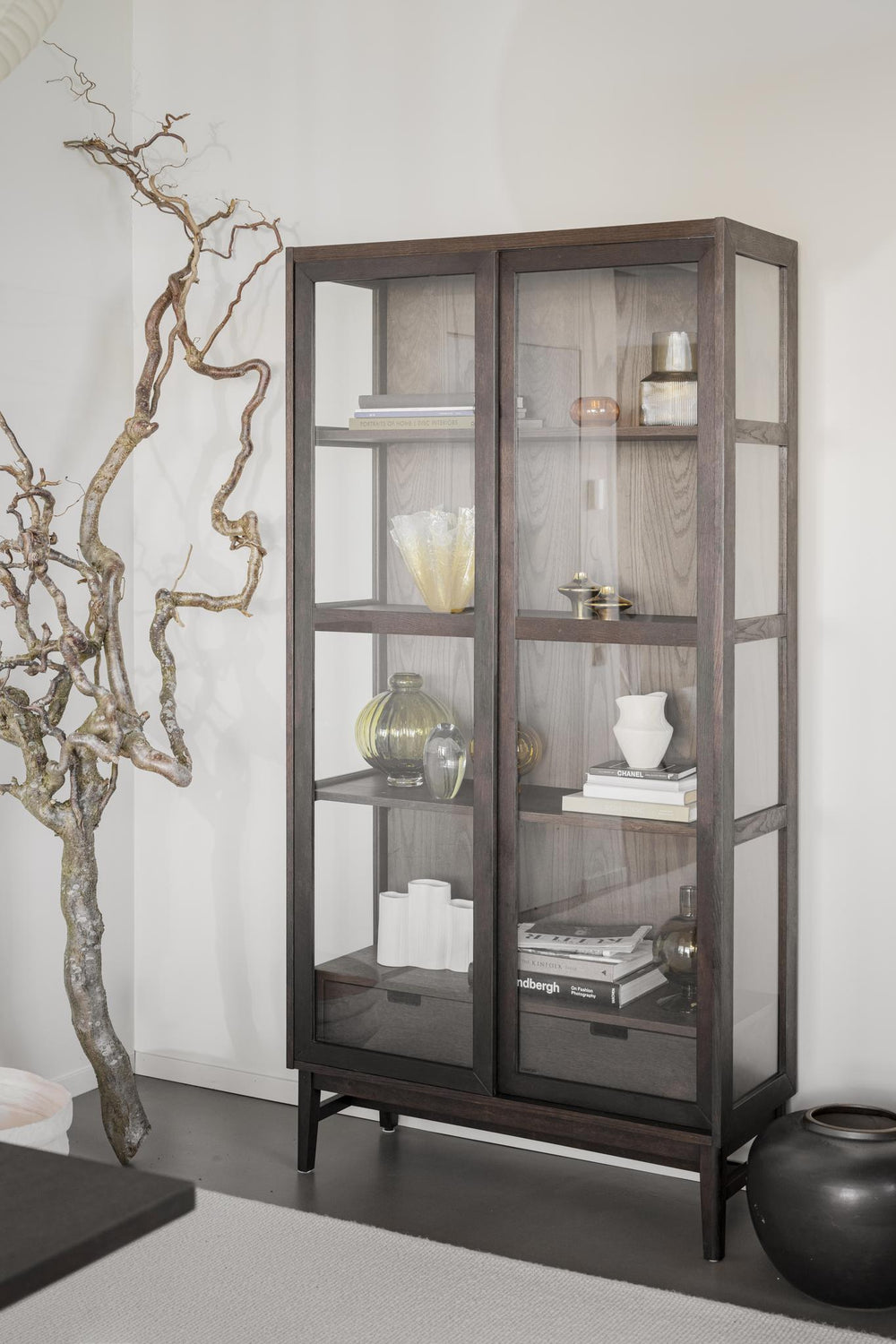 Vitrinskåp i mörkt trä med glasdörrar och fyra hyllplan, modern design