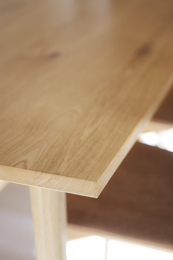 Närbild på ljust träbord med synlig trästruktur och naturlig ådring i ek eller björk
