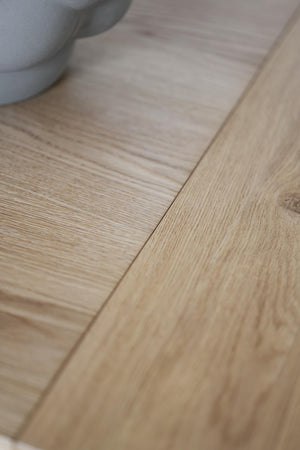 Ljust trägolv i ek med synliga årsringar och naturlig struktur, närbild av plankorna