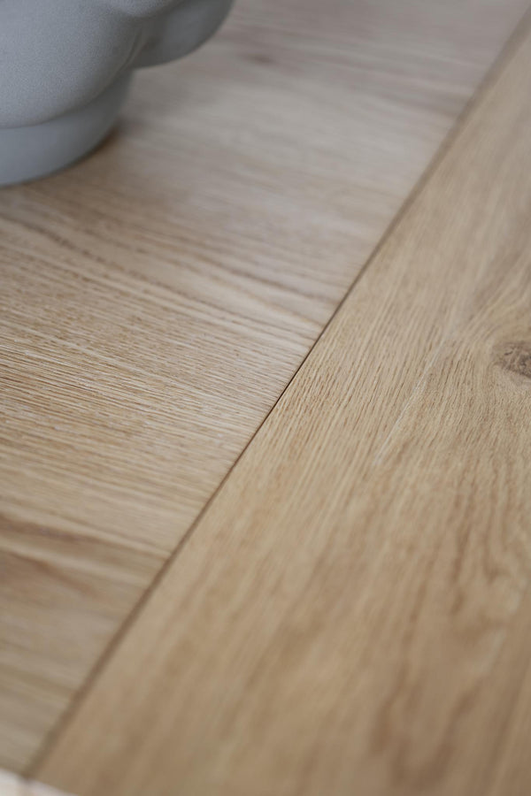 Ljust trägolv i ek med synliga årsringar och naturlig struktur, närbild av plankorna