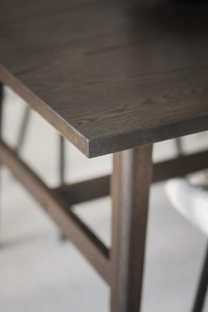 Närbild på mörkbrun träskiva med synlig struktur och slipade kanter på träbord eller möbel