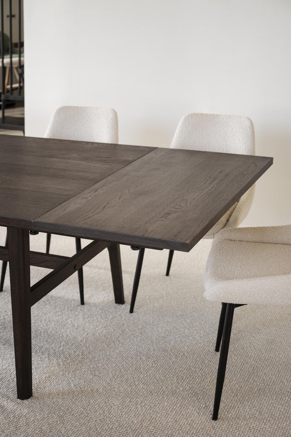 Utdragbart matbord i grå ek med svarta ben och beige stoppade stolar i modern matsal
