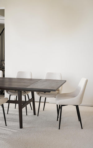 Matgrupp med grått bord och vita stoppade stolar i modern skandinavisk stil