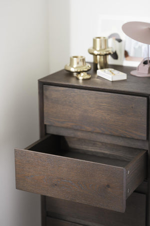 Sängbord i mörkt trä med öppen låda och dekorativa gulddetaljer på toppen