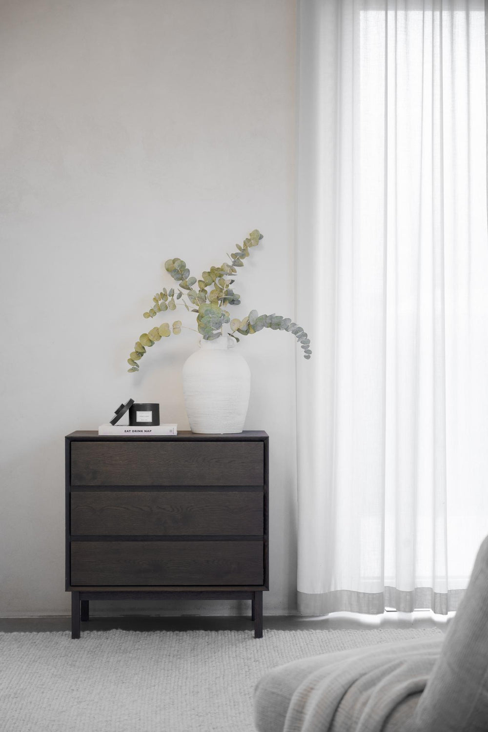 Mörkbrun sängbord med tre lådor och benställning i trä, modern skandinavisk design