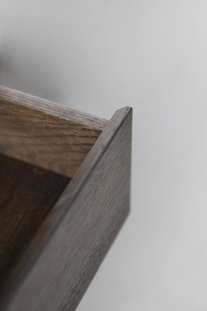 Närbild på hörn av träram i gråbrun ek med synlig trästruktur och snickardetaljer