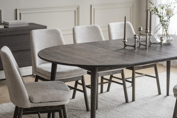 Grå matbord i trä med upholsterade stolar i ljust tyg, elegant skandinavisk design för matsalen