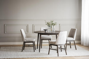 Matgrupp med runt bord och fyra stoppade stolar i beige tyg, mörkbrun träfinish, skandinavisk design