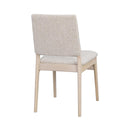 Beige stoppad matstol med ljust träben, sedd från sidan mot vit bakgrund