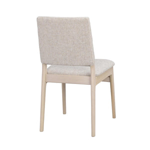 Beige stoppad matstol med ljust träben, sedd från sidan mot vit bakgrund