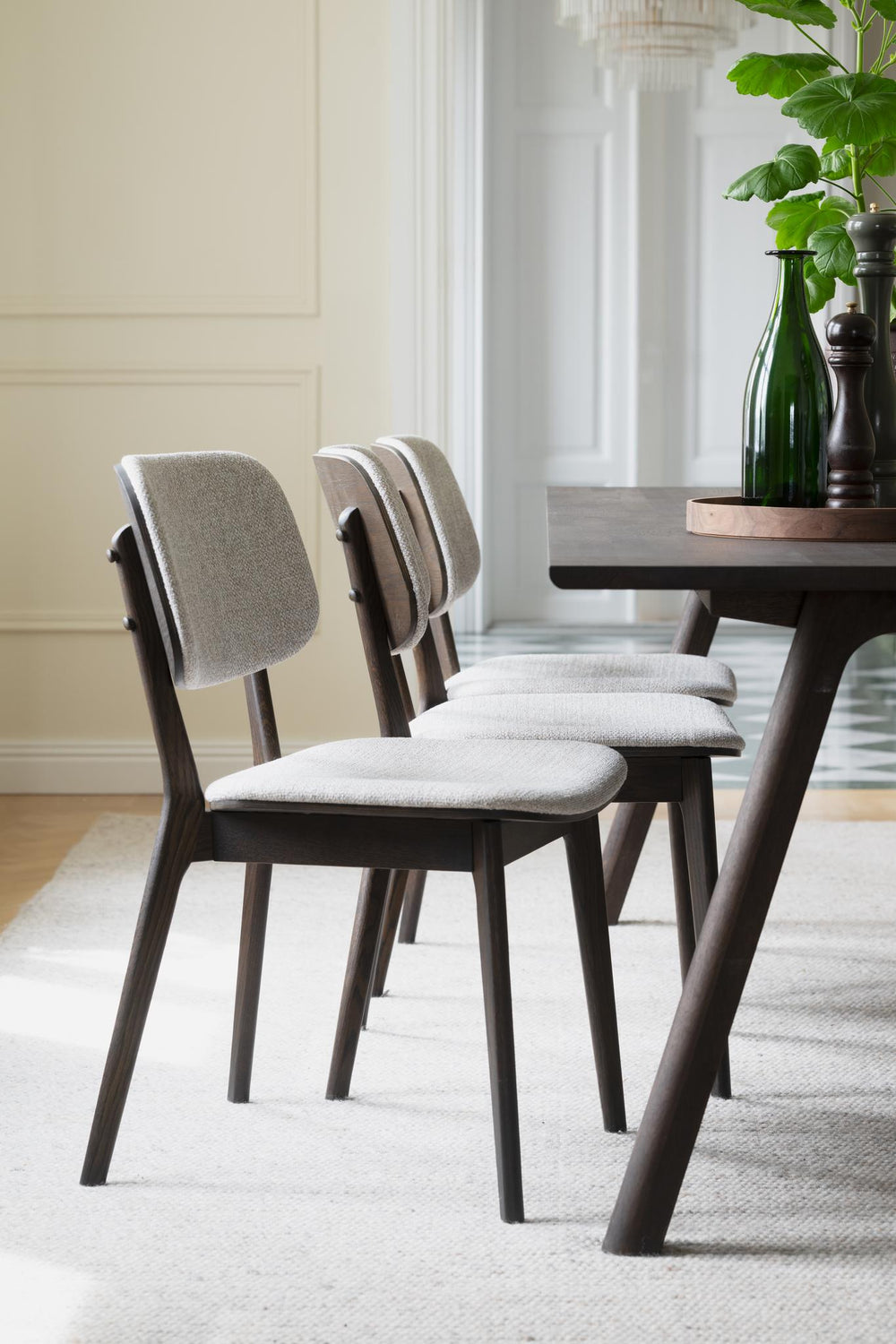 Stol med beige klädsel och mörka träben i modern skandinavisk design