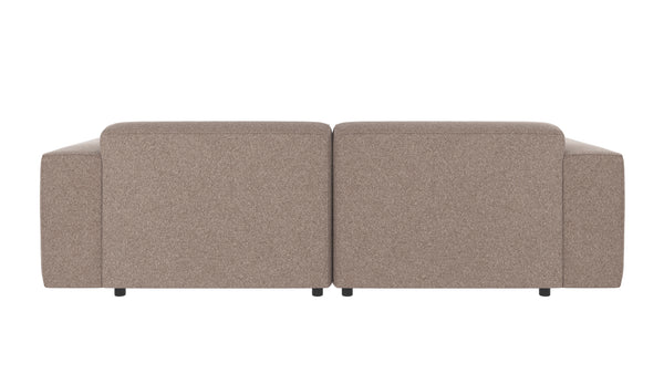 Beige tvåsitssoffa i tyg sedd bakifrån med mjuka armstöd och svarta ben