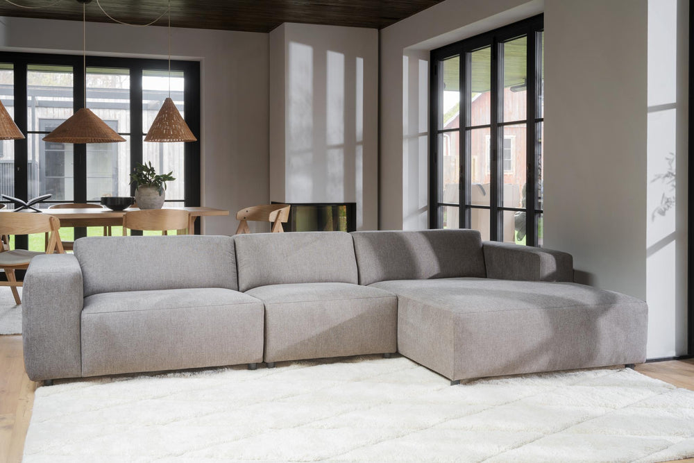 Beige modulsoffa med schäslong i textil med tre sittplatser och låga ben