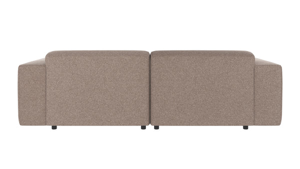 Beige tvåsits soffa sedd bakifrån med mjuka kuddar och låga ben i modern design