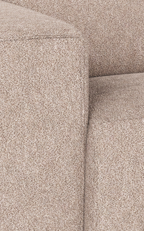 Närbildsdetalj av beige soffa i tovad textil med synliga sömmar och mjuk struktur