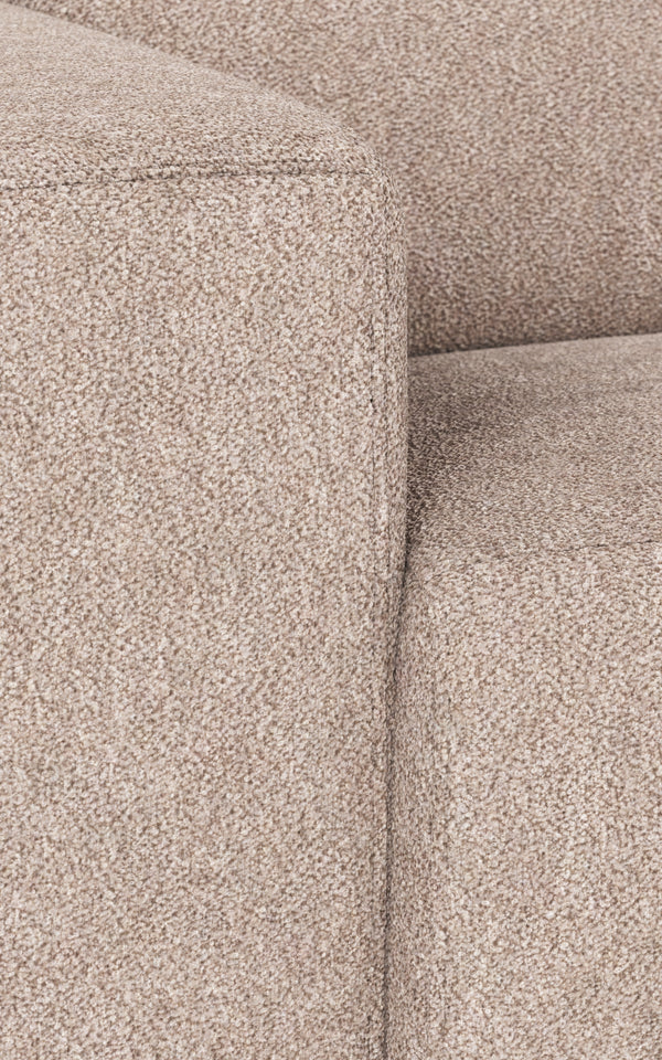 Beige soffa i mjukt tyg med detaljbild på armstöd och sömmar i närbild