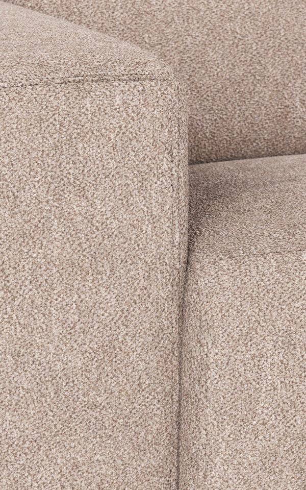 Närbildsdetalj av beige soffa med strukturerad klädsel och synliga sömmar