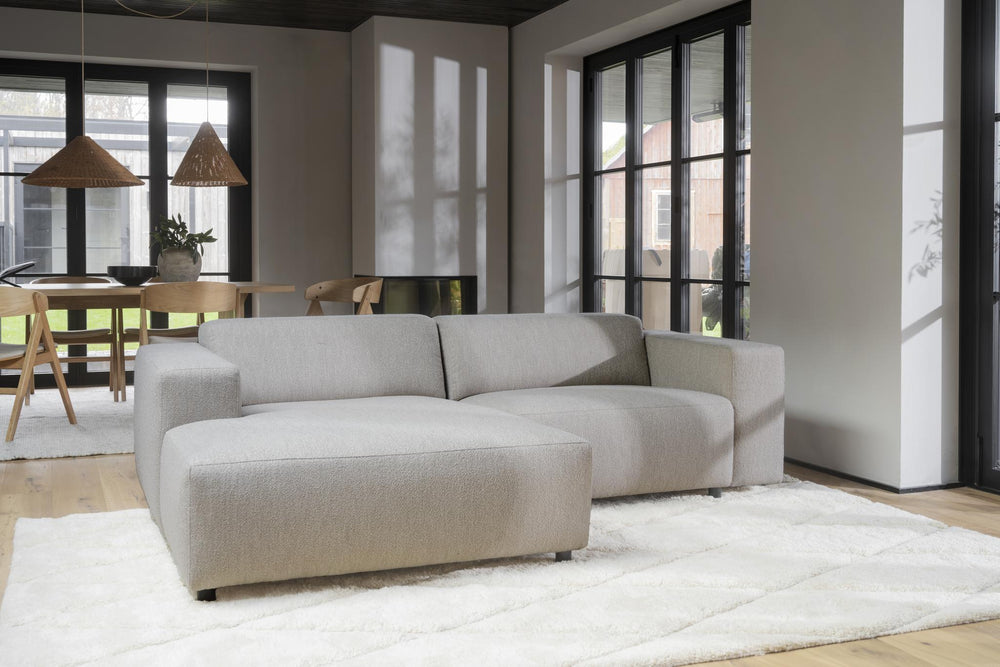 Beige tvåsits soffa med schäslong i vänsterställning, mjuk klädsel och moderna svarta ben