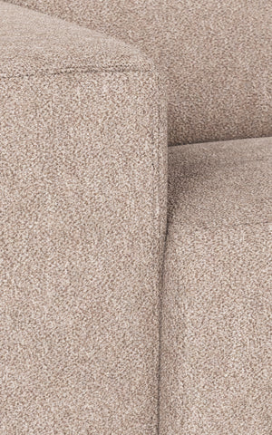 Beige soffa i tygklädsel med mjuk textur och synliga sömmar i närbild