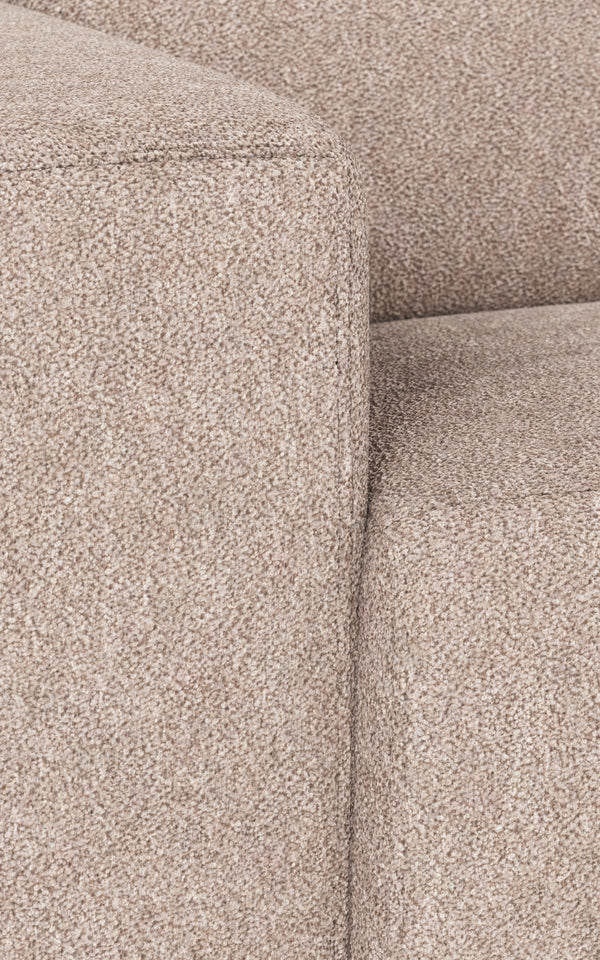 Beige soffa i tygklädsel med mjuk textur och synliga sömmar i närbild