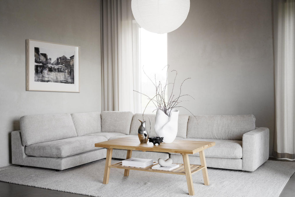 Beige L-formad modulsoffa med tre sits- och en hörndel i ljust tyg mot vit bakgrund