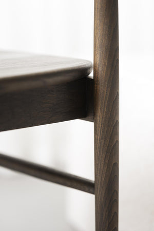 Närbild på möbelben i mörkt trä med synlig trästruktur och rundad bordskant