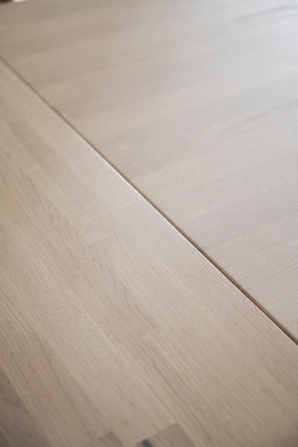 Ljust trägolv med synlig trästruktur och fог mellan plankorna i naturlig ek