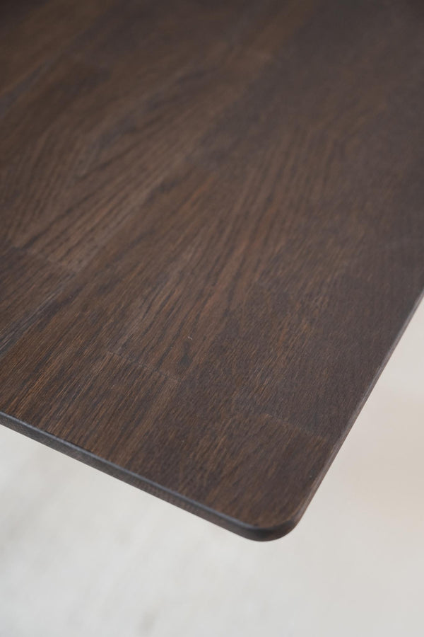 Närbild av mörkt träbord med synlig textur och ådringsmönster i brun och svart nyans