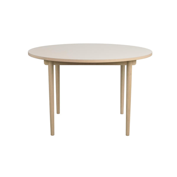 Runt matbord i ljust trä med fyra ben och enkel skandinavisk design