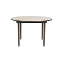 Runt matbord med ljus skiva och mörka träben, modernt skandinavisk design