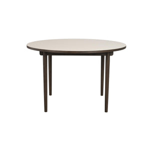 Runt matbord med ljus skiva och mörka träben, modernt skandinavisk design