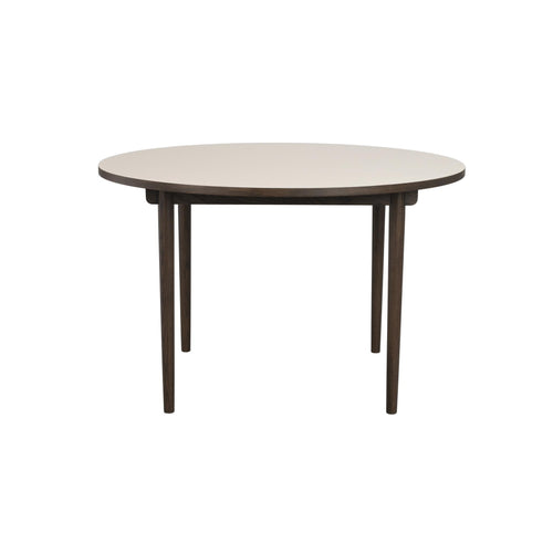 Runt matbord med ljus skiva och mörka träben, modernt skandinavisk design