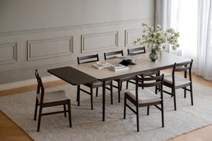 Matgrupp med bord i mörkt trä och sex stolar med beige stoppad sits i elegant matsal