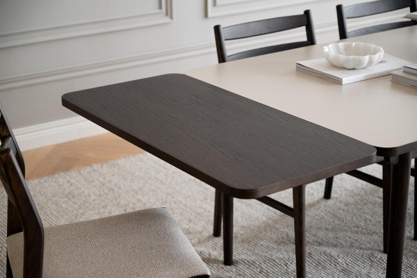 Mörkbrun träbänk vid matbord med stolar i modern matsal med ljus matta