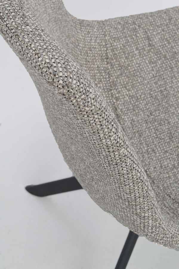 Närbild på grå textilklädsel med flerfärgad melerad struktur på stolsarm och ryggstöd